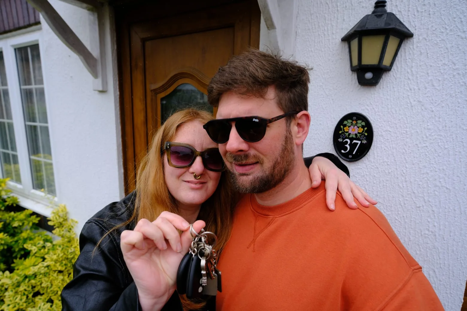 Nico and Rosie outside their new house, holding the keys.